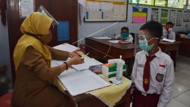 Murid SD mengikuti simulasi belajar tatap muka dengan menerapkan protokol kesehatan pencegahan penularan COVID-19 di SDN 1 Kare, Kabupaten Madiun, Jawa Timur, Senin (14/12/2020). Simulasi tersebut sebagai persiapan pelaksanaan belajar secara tatap muka pada masa pandemi COVID-19 yang akan dimulai 4 Januari 2021. ANTARA FOTO/Siswowidodo/aww.