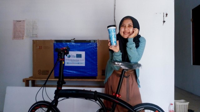 Mahasiswi UNS Ulifah menunjukkan hadiah berupa sepeda dan tempat minum dalam kompetisi yang diikutinya