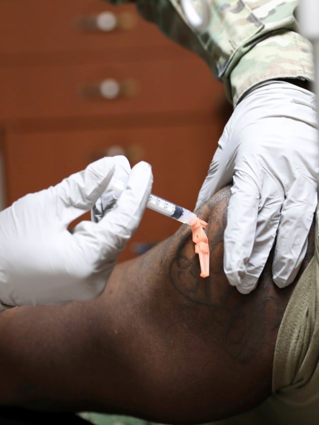 Sejumlah tentara Angkatan Udara AS mengantre untuk mendapat vaksin virus corona di Pangkalan Udara Osan di Pyeongtaek, Korea Selatan, Selasa (29/12). Foto: United States Forces Korea via AP
