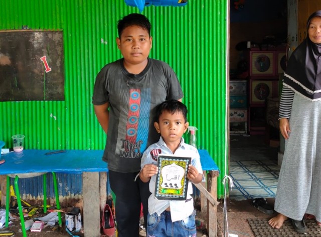 Wahyu (11), dan adiknya Putra (5) sedang berada di rumahnya usai mendapat bantuan dari Kapolres Kendari. Foto: Istimewa.