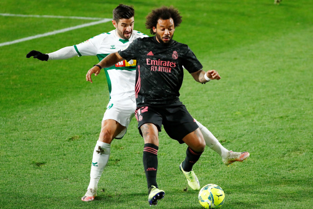 Pemain Real Madrid Marcelo berusaha melewati hadangan pemain Elche pada pertandingan lanjuta Liga Spanyol di Estadio Manuel Martinez Valero, Elche, Spanyol. Foto: Juan Medina/REUTERS