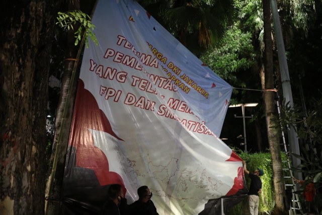Warga memasang baliho bertuliskan ucapan "terimakasih kepada pemerintah Indonesia yang telah membubarkan FPI dan simpatisannya" di kawasan Thamrin. Foto: Aditia Noviansyah/kumparan