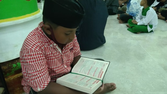 Tampak salah satu anak TPA Masjid Waisai, Raja Ampat, khusyu membaca Al-Qur'an menyambut malam pergantian tahun 2020-2021, foto : Yanti/Balleo News