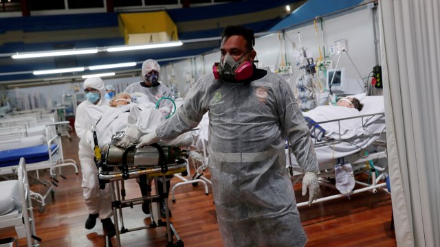 Petugas medis melakukan penghomatan untuk korban COVID-19 di sebuah rumah sakit lapangan untuk pasien corona di Santo Andre, negara bagian Sao Paulo, Brasil, Kamis (31/12). Foto: Amanda Perobelli/REUTERS