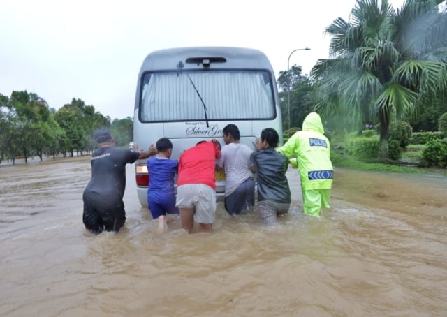 Warga membantu kendaraan yang terjebak banjir di ruas jalan di Kota Batam. Foto: Rega/kepripedia.com