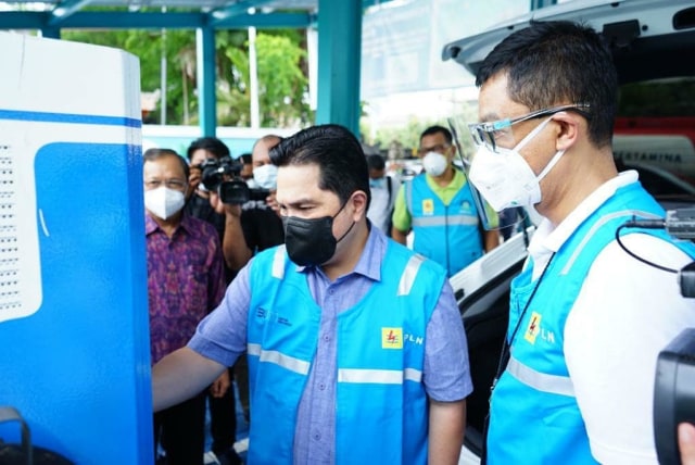 Menteri BUMN Erick Thohir (tengah) mencoba mengisi ulang baterai mobil listrikdi charging station (SPKLU) milik PLN.  Foto: Instagram/@erickthohir