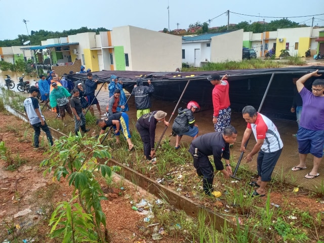 ﻿﻿Personel Satbrimob Polda Kepri dibantu warga mendirikan posko penanganan banjir. Foto: Istimewa