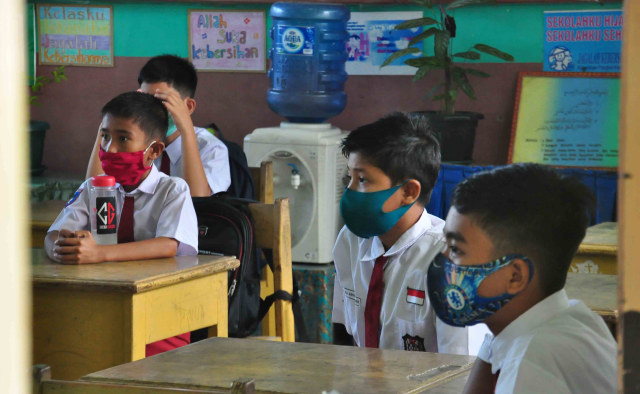 Para siswa SDN Percobaan Padang, Sumatera Barat, memakai masker di dalam kelas saat mengikuti proses belajar tatap muka yang dilangsungkan dalam kondisi pandemi COVID-19 pada Senin 4 Januari 2021. Foto: Ahmad/Langkanid/Kumparan
