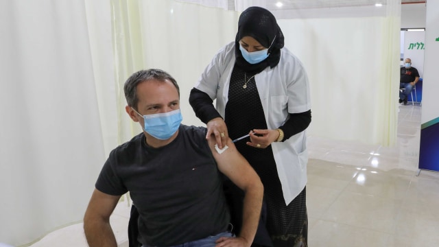 Vaksinasi COVID-19 di pusat vaksinasi di Umm El-Fahem, Israel. Foto: AMMAR AWAD/REUTERS