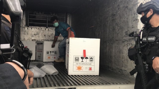 ANGGOTA Brimob bersenjatakan laras panjang mengawal pengangkutan 20 ribu dosis Vaksin Sinovac dikirim oleh PT Bio Farma, Bandung, Jawa Barat, menuju Pekanbaru, Riau, Selasa (5/1/2021). 