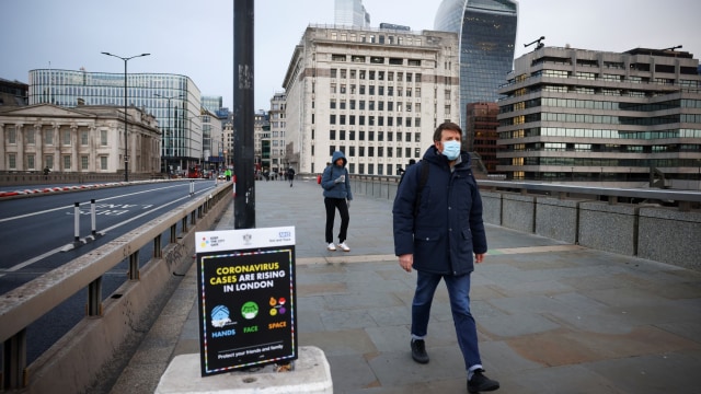 Warga mengenakan masker berjalan di Jembatan London, London, Inggris, Selasa (5/1). 
 Foto: Henry Nicholls/REUTERS