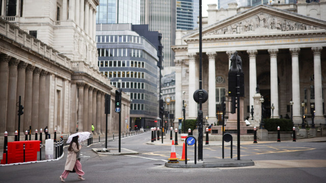 Warga mengenakan masker berjalan di dekat Bank Junction, London, Inggris, Selasa (5/1).  Foto: Henry Nicholls/REUTERS
