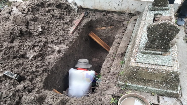 Petugas penggali kubur saat temukan sesosok jasad yang masih utuh di tempat pemakaman khusus bagi jemaah Masjid Darussalam Kota Bojonegoro. Selasa (05/01/2021). (foto: dan/beritabojonegoro)
