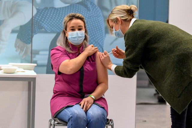 Suster panti jompo berusia 39 tahun, Sanna Elkadiri menerima vaksin Pfizer / BioNTech pertama di Belanda di Veghel, Belanda, Rabu (6/1).  Foto: Piroschka van de Wouw/Pool/REUTERS