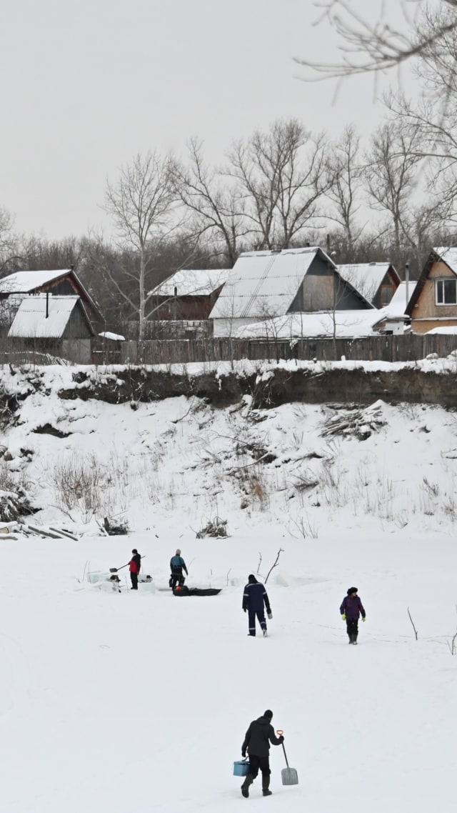 Penyelam Rusia, bersama dengan ilmuwan dan penggemar paleontologi, menyiapkan lubang es di Sungai Tobol yang membeku, untuk mencari tulang dan gigi hewan punah, di Kurgan, Rusia. Foto: Alexey Malgavko/REUTERS