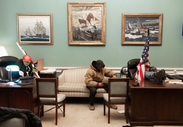 Pendukung Presiden AS Donald Trump duduk di dalam kantor Ketua DPR AS Nancy Pelosi saat ia melakukan protes di dalam US Capitol di Washington, DC.
 Foto: Saul Loeb/AFP