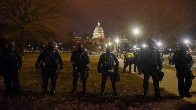 Pasukan keamanan berjaga-jaga karena lingkungan di sekitar Capitol AS kosong selama jam malam di Washington, AS, (6/1). Foto: Stephanie Keith/REUTERS