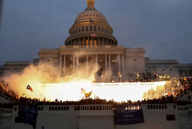 Sebuah ledakan yang disebabkan oleh amunisi polisi terlihat saat para pendukung Presiden AS Donald Trump berkumpul di depan Gedung Capitol AS di Washington, AS, 6 Januari 2021. Foto: Leah Millis/REUTERS