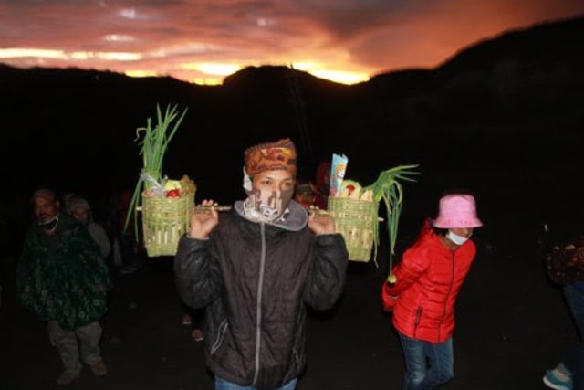 Warga tengger mengenakan masker dan membawa sayuran untuk dilarung dalam rangkaian kasada. Foto: Ben