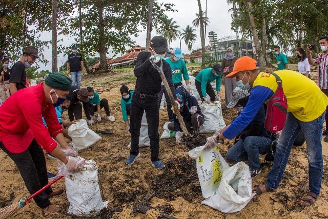 Wakil Wali Kota Batam, Amsakar Achmad ikut bergotong royong membersihkan limbah minyak di Pantai Nongsa. (Foto: ist)