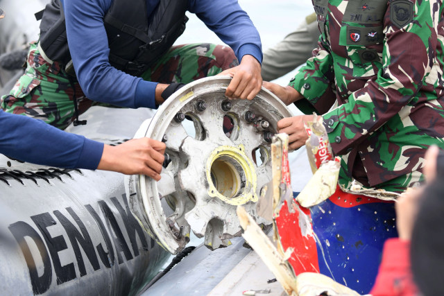Prajurit Batalyon Intai Amfibi 1 Korps Marinir (Yontaifib) TNI AL memegang serpihan pesawat Sriwijaya Air SJ 182 yang hilang kontak saat melakukan pencarian di perairan Kepulauan Seribu, Jakarta, Minggu (10/1).  Foto: M Risyal Hidayat/ANTARA FOTO