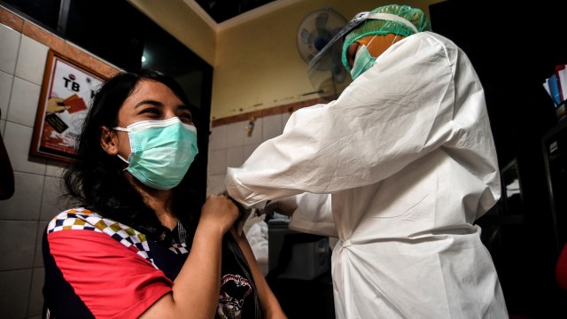 Petugas kesehatan memberikan contoh cara memvaksin seorang pasien saat simulasi pemberian vaksin corona Sinovac di Puskesmas Kelurahan Cilincing I, Jakarta, Selasa (12/1).  Foto: Muhammad Adimaja/ANTARA FOTO