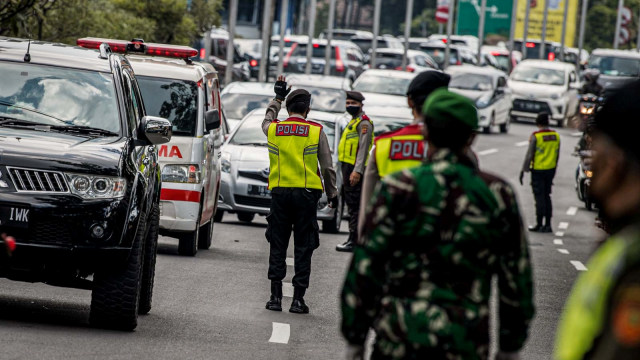 Petugas gabungan mengatur lalu lintas kendaraan dari luar kota saat penerapan Pembatasan Sosial Berskala Besar (PSBB) di Pasteur, Bandung, Jawa Barat. Foto: M Agung Rajasa/ANTARA FOTO