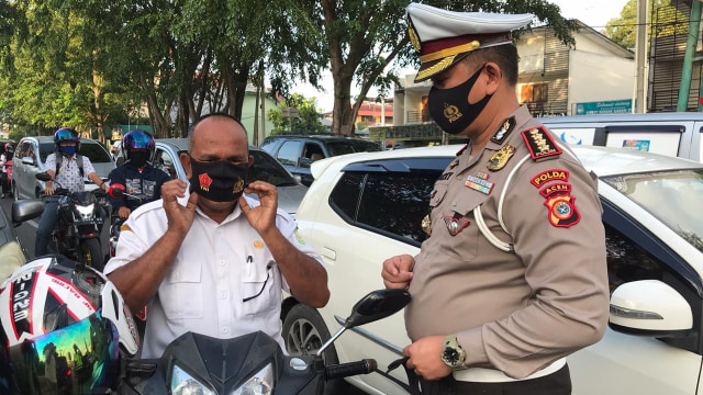 Ditlantas Polda Aceh melakukan pemantauan dan pengawasan terhadap warga agar mematuhi protokol kesehatan di kawasan lampu merah, Simpang Lima Kota Banda Aceh. Foto: Dok. Ditlantas Polda Aceh