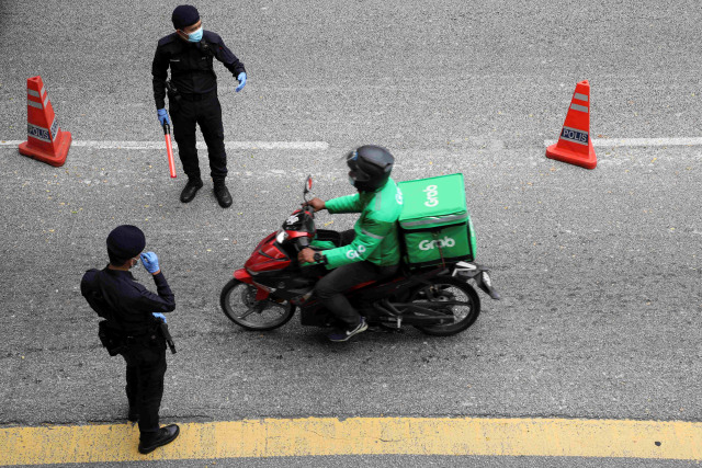 Polisi melakukan pemeriksaan saat lockdown di Kuala Lumpur, Malaysia. Foto: Lim Huey Teng/Reuters