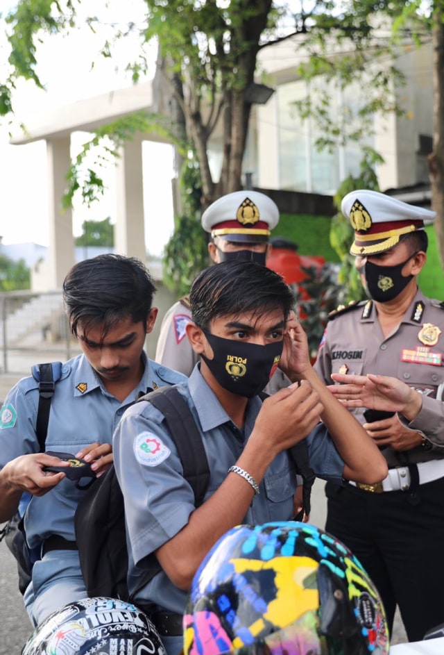Polisi bagi masker kepada anak sekolah. Foto: Suparta/acehkini