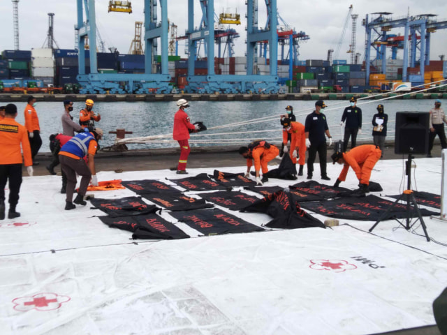 Tim SAR turunkan sejumlah kantong yang berisi bagian tubuh korban dan serpihan pesawat dari KN SAR Karna, di JICT, Tanjung Priok, Jakarta Utara, Kamis (14/1). Foto: Fachrul Irwinsyah/kumparan