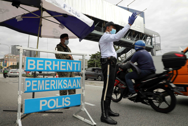 Polisi dan tentara melakukan pemeriksaan saat lockdown di Kuala Lumpur, Malaysia. Foto: Lim Huey Teng/Reuters
