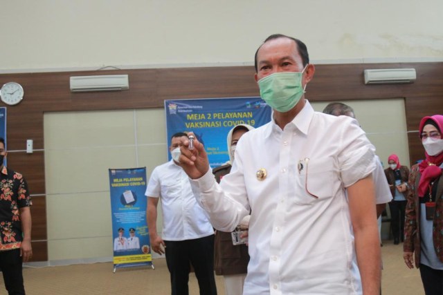 Wali Kota Palembang, Harnojoyo, menunjukkan vaksin corona. (foto: Eko Nurhadi for Urban Id)