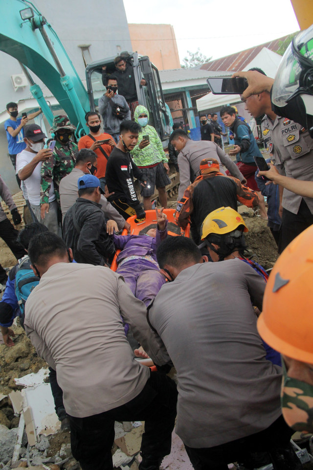 Petugas mengevakuasi korban yang terjepit bangunan di rumah sakit Mitra Manakarra yang runtuh akibat gempa bumi di Mamuju, Sulawesi Barat, Kamis (15/1).  Foto: Akbar Tado/ANTARA FOTO