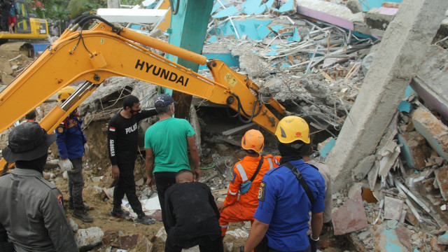 Sejumlah petugas dengan alat berat mencari korban di Rumah Sakit Mitra Manakarra yang runtuh akibat gempa bumi, di Mamuju, Sulawesi Barat, Kamis (15/1). Foto: Akbar Tado/ANTARA FOTO