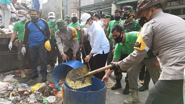 KAPOLDA Riau, Irjen Pol Agung Setya Imam Effendi (kanan) bersama-sama dengan Ketua DPRD Riau, Yulisman dan Danrem 031/WB Brigjen TNI M Syeh Ismed, gotong-royong angkut sampah yang menumpuk di Jalan Cempaka, Pekanbaru.