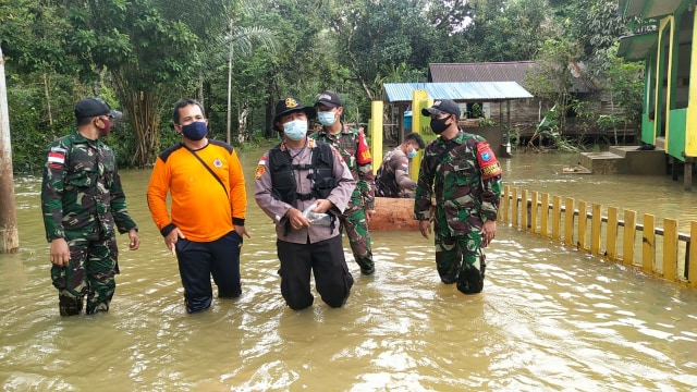 Kapolsek Jagoi Babang, AKP Andri bersama anggota TNI meninjau lokasi banjir di Kecamatan Jagoi Babang, Bengkayang. Foto: Dok Hi!Pontianak