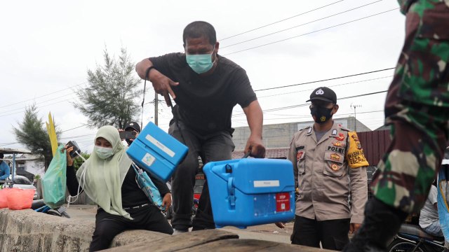 Petugas mengangkat boks khusus dosis vaksin corona Sinovac untuk dibawa ke Pulo Aceh dengan menggunakan perahu motor penumpang, Sabtu (16/1). Foto: Suparta/acehkini