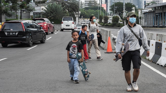 Dua orang warga tidak menggunakan masker saat melintas di daerah Sudirman, Jakarta, Sabtu (16/1). Foto: Fakhri Hermansyah/ANTARA FOTO