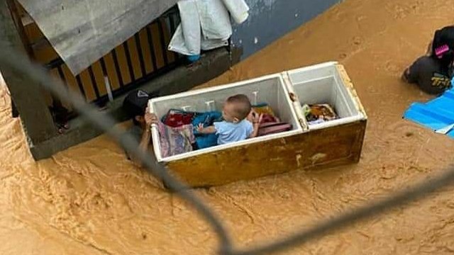 Usaha orang tua menyelamatkan anak dari banjir. (Foto: @giewahyudi/Twitter)