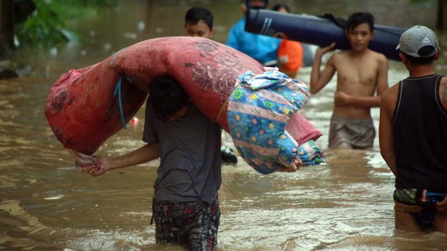 Warga Manado mengangkat barang untuk mengungsi setelah banjir menggenangi wilayah mereka. (foto: febry kodongan/manadobacirita)