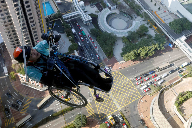 Lai Chi-wai, seorang pendaki yang lumpuh, mencoba memanjat Menara Nina setinggi 320 meter hanya dengan menggunakan kekuatan tubuh bagian atas, di Hong Kong, China. Foto: Tyrone Siu/Reuters