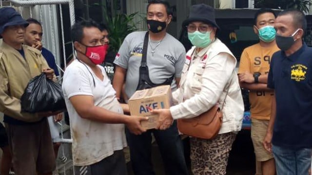 Ketua Baguna PDIP Sulawesi Utara, Adriana Dondokambey menyerahkan bantuan kepada warga korban banjir Manado