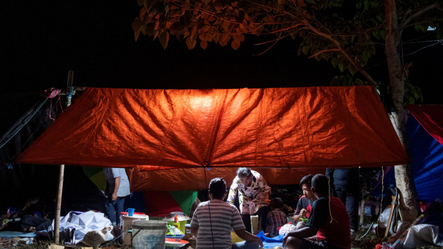 Sejumlah pengungsi korban gempa makan malam di tenda darurat yang mereka buat di kompleks Stadion Manakarra, Mamuju, Sulawesi Barat, Minggu (17/1). Foto: Sigid Kurniawan/ANTARA FOTO
