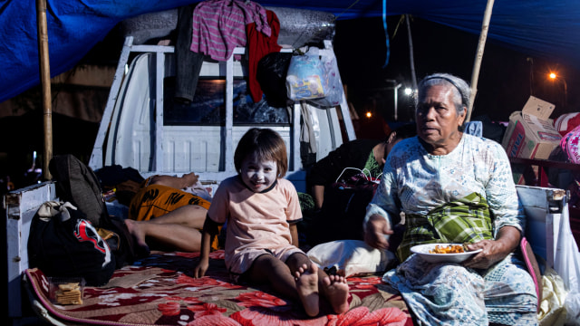 Sejumlah pengungsi korban gempa beristirahat di tenda darurat yang mereka buat di kompleks Stadion Manakarra, Mamuju, Sulawesi Barat, Minggu (17/1).  Foto: Sigid Kurniawan/ANTARA FOTO