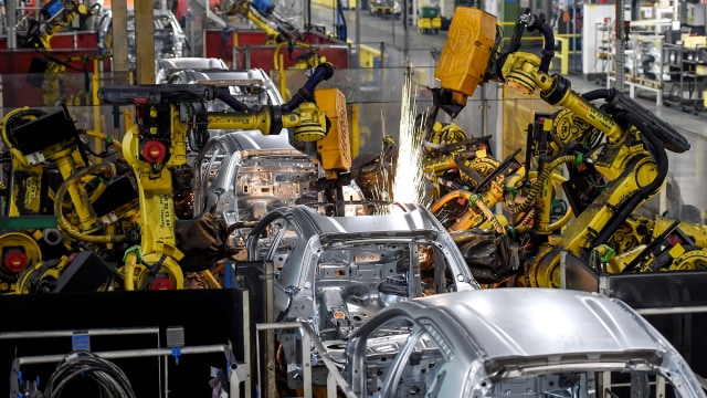 Robot merakit kerangka kendaraan di jalur perakitan di pabrik pembuat mobil Prancis PSA Peugeot Citroen. Foto: SEBASTIEN BOZON/AFP