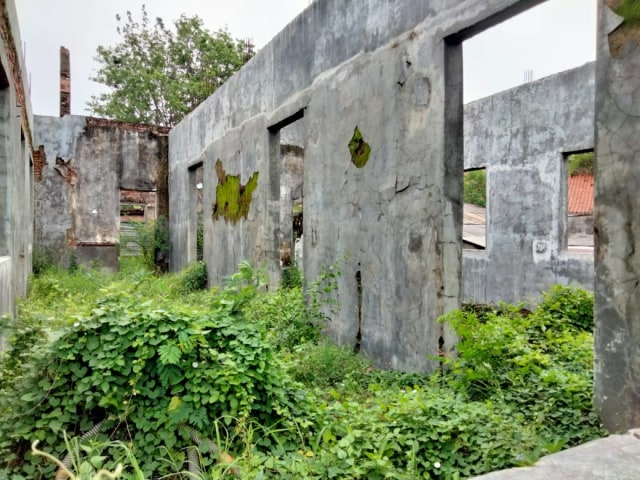 Bangunan tempat mesin pompa Riol disimpan nampak dipenuhi tumbuhan liar. (Juan)
