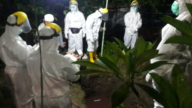 Proses pemakaman jenasah pasien COVID -19 berinisial NA, warga Desa Pepedan, Kecamatan dukuhturi, Senin (18/1) malam. (Foto: Istimewa)