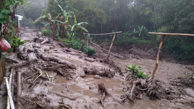 Jalan desa penghubung Agrowisata Gunung Mas Puncak yang digenangi lumpur sisa banjir bandang, Bogor, Jawa Barat, Selasa (19/1). Foto: Dok. Istimewa