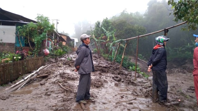 Jalan desa penghubung Agrowisata Gunung Mas Puncak yang digenangi lumpur sisa banjir bandang, Bogor, Jawa Barat, Selasa (19/1). Foto: Dok. Istimewa